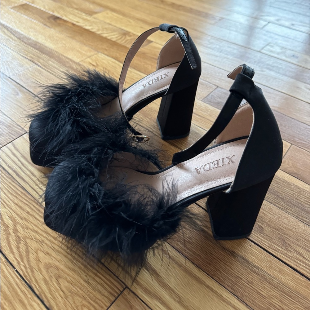 Black satin platform heels with feathers.